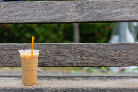 Coffee cool moment the sun is low. On a wooden chair in the parkの写真素材