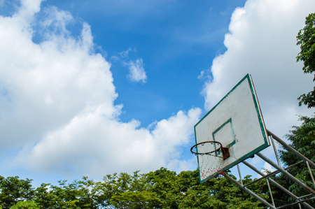 A broken basketball hoop over a bright sunny day blue skyの写真素材