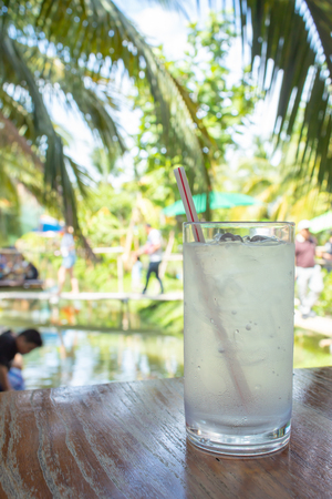 Water ice in the glass on the wooden table in garden.の写真素材