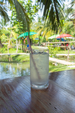 Water ice in the glass on the wooden table in garden.の写真素材