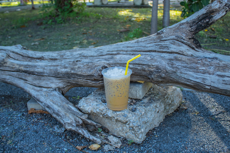 Iced coffee is placed with a log.の写真素材