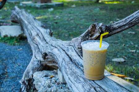 Iced coffee is placed with a log.の写真素材