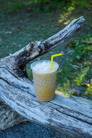 Iced coffee is placed with a log.の写真素材