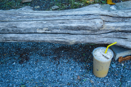 Iced coffee is placed with a log.の写真素材
