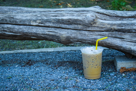 Iced coffee is placed with a log.の写真素材