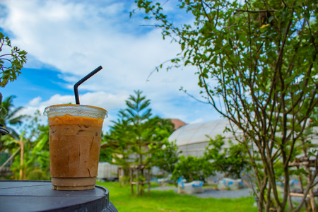 Iced coffee on a wooden table in the garden.の写真素材