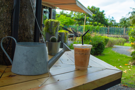 Iced coffee on a wooden table in the garden.の写真素材