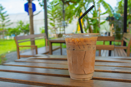 Iced coffee on a wooden table in the garden.の写真素材