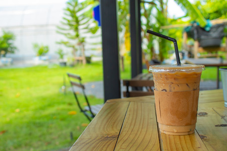 Iced coffee on a wooden table in the garden.の写真素材