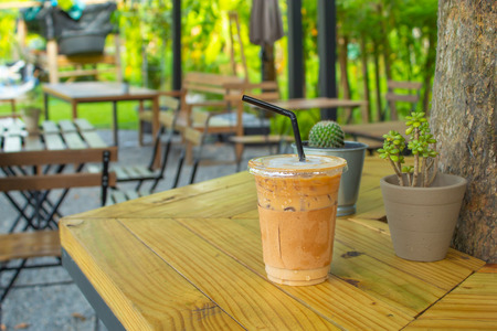 Iced coffee on a wooden table in the garden.の写真素材