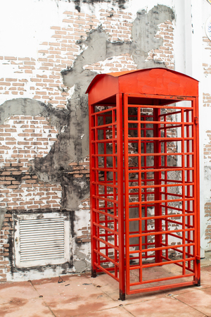 Red telephone box front brick wall block.の写真素材