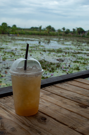 Sweet water from sugar palm on the table ,With the beauty of the Lotus pond.の写真素材