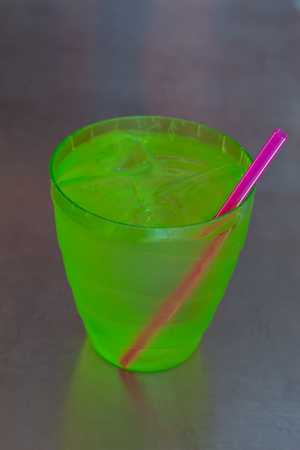 Cold water in green plastic cup on Stainless steel table.の写真素材