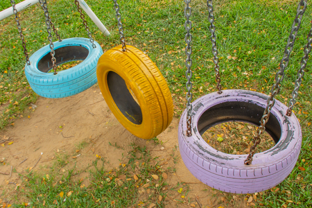 Swing chairs made from old tires  for children in park.の写真素材