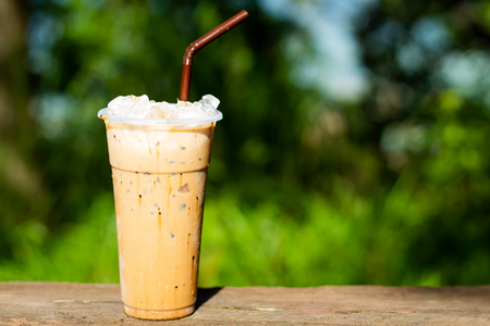 Iced coffee and a background of green trees.の写真素材