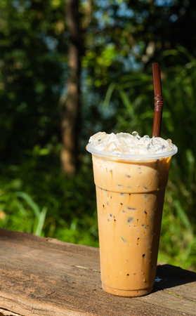 Iced coffee and a background of green trees.の写真素材