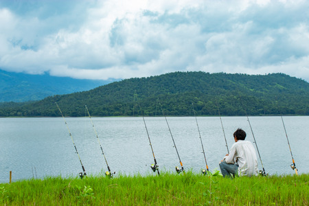 Fishermen sit fishing at the Huai Pa Daeng Reservoir , Phetchabun in  Thailand.の写真素材