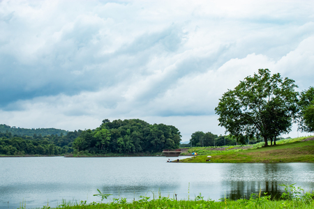 Fishermen sit fishing at the Huai Pa Daeng Reservoir , Phetchabun in  Thailand.の写真素材