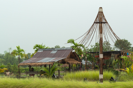 A wooden shack thatched straw and zinc of the rain flows into the well.の写真素材