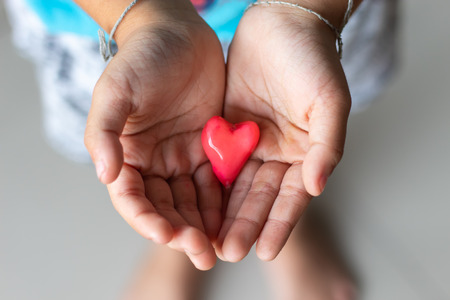 Candy red heart in hand a boy.の写真素材