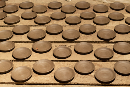 Clay plate placed on the wood to dry before the fireの写真素材