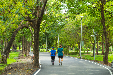 Man and woman walking on the street in the park.の写真素材