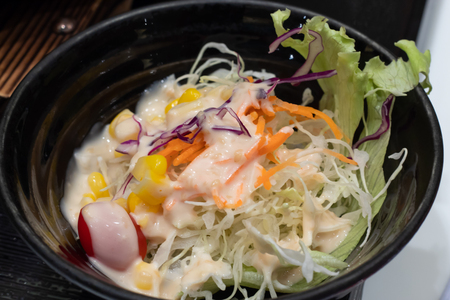 Vegetable salad in a black cup on the table.の写真素材