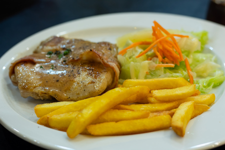 Chicken steak with French fries and salad.の写真素材