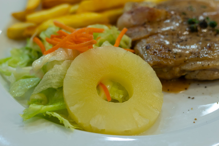 Chicken steak with French fries and salad.の写真素材