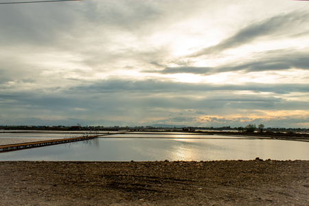 Sunset light reflects from the surface of the water and the wooden bridge.の写真素材