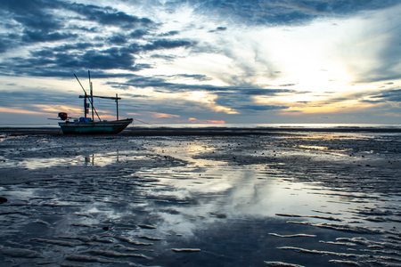 The morning sun light in the sea, and the boat on the beach.の写真素材