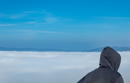 Tourists are watching the fog on the mountain.