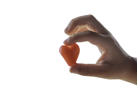 Isolated Hand holding a red candy shape heart on a white background with clipping path.