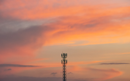 Evening sunset light is orange after the telephone receiver antenna.の写真素材