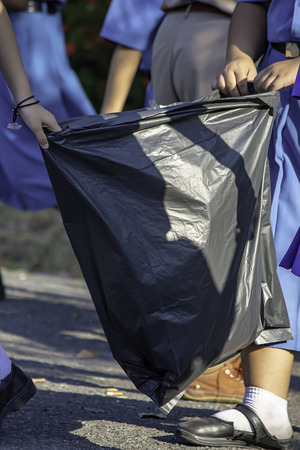 Hand Asean girl holding Black garbage bags.の写真素材