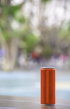 Canned drink red on the wooden chair Background blurry trees in gardenの写真素材