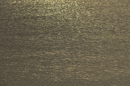 Blurry water waves by wind and sunlight reflecting surface