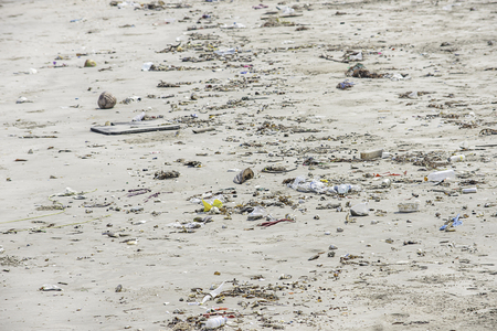 Waste bottles, glass and bag made of plastic on the beach.の写真素材