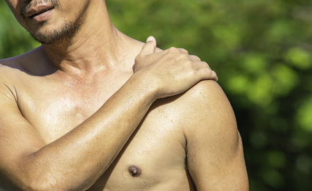 The hand grips the shoulder that inflammation from a sports injury.の写真素材