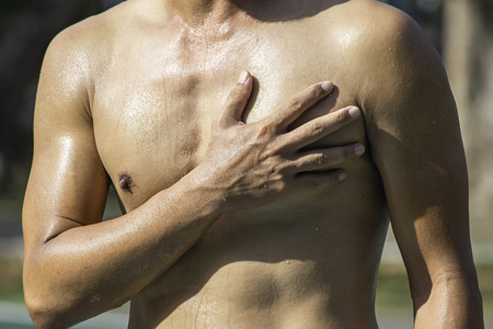 The hand grips the chest that inflammation from a sports injury.の写真素材
