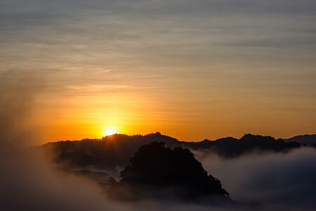 Sunrise and morning light behind the mountains with the mist covered.の写真素材