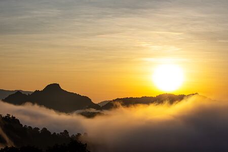 Sunrise and morning light behind the mountains with the mist covered.の写真素材