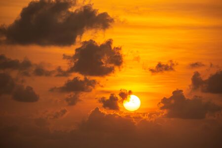 The golden light of the morning sun and clouds in the sky.の写真素材