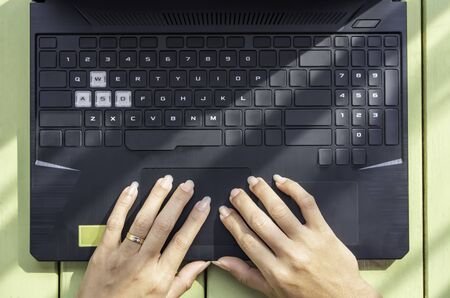 Hand and notebook On the yellow wooden table.の写真素材