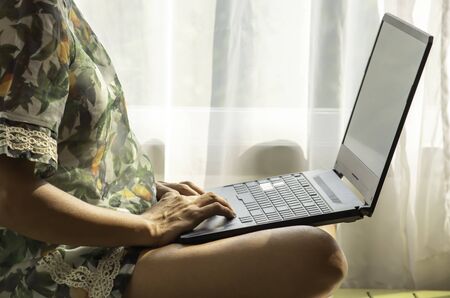 Hand Women work with notebooks on the wooden bed  Background white curtains and natural light.の写真素材