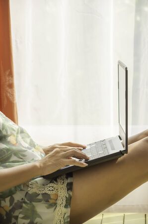 Hand Women work with notebooks on the wooden bed   white curtains and natural light.の写真素材