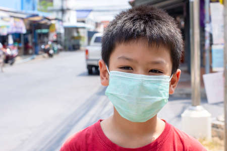 Asian boy wearing a mask Standing on the street in Bangkok ,Thailand.のeditorial素材