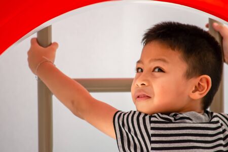 Portrait of Asian boys are climbing the ladder in the playground.の写真素材