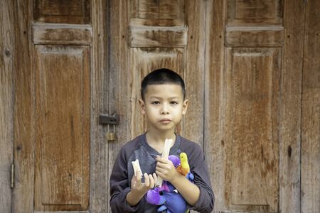 boy was eating bread Background wall of wood.の写真素材