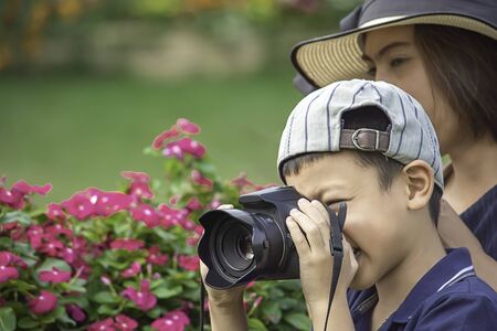 Hand boy holding the camera Taking pictures in park.の写真素材